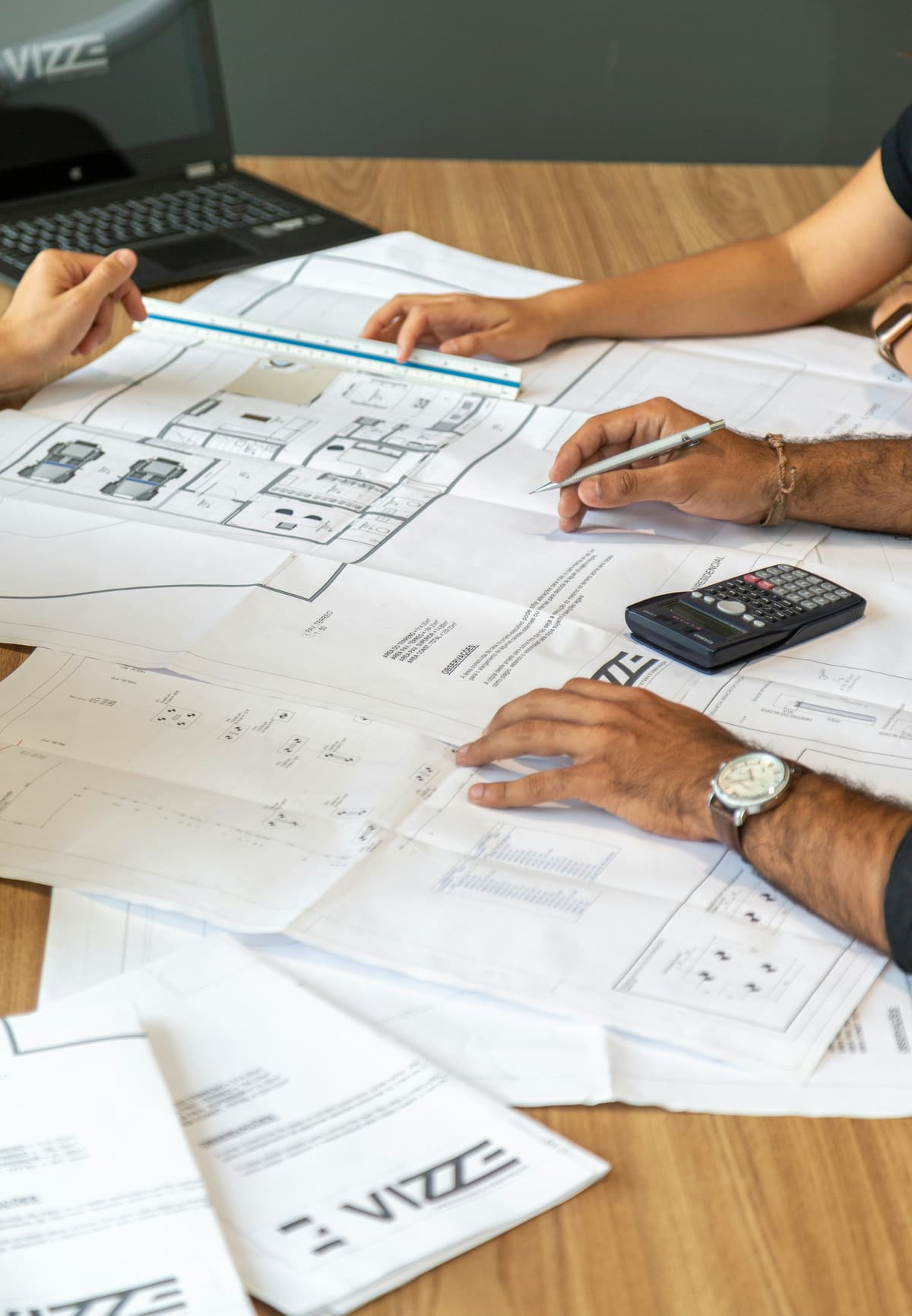 Two people reviewing architectural drawings at a desk